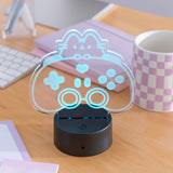 Gamer Pusheen Otaku Lamp shows Pusheen the Cat peeking over a gaming controller. The lamp is shown in daylight to demonstrate the LED light. 