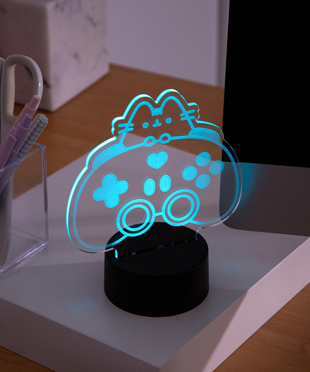 Gamer LED Lamp of Pusheen the Cat and a controller sits on a desktop in twilight.