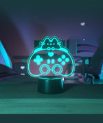Teal blue gaming lamp of Pusheen the Cat and a gaming controller on a desktop.