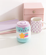 Gamer Pusheen Pop Sup Plush sits next to a coffee mug to demonstrate the size of the energy drink can inspired plush.