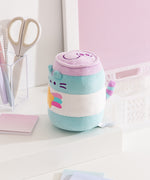 Side view of the plush. The blue and white stripes continue around the entire cylindrical plush. From this view Pusheen's striped tail can be seen extending off the back of the plush.