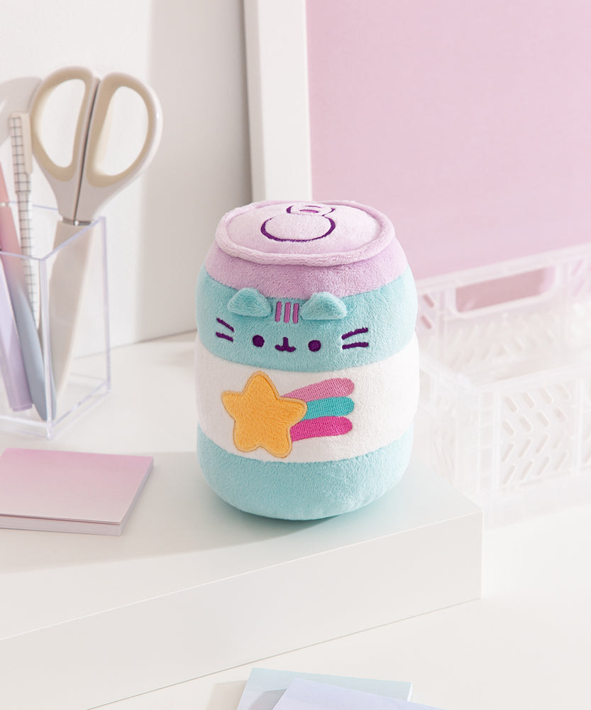 Quarter side view of the can shaped plush toy. Pusheen the Cat's three head stripes are embroidered in a purple color that matches the lid color of the can. The stripes are placed between the triangle shaped ears that extend off the front of the plush.