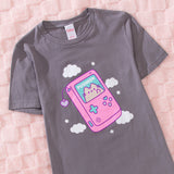 Close-up of the gray t-shirt with a large printed graphic of a gameboy style console. 