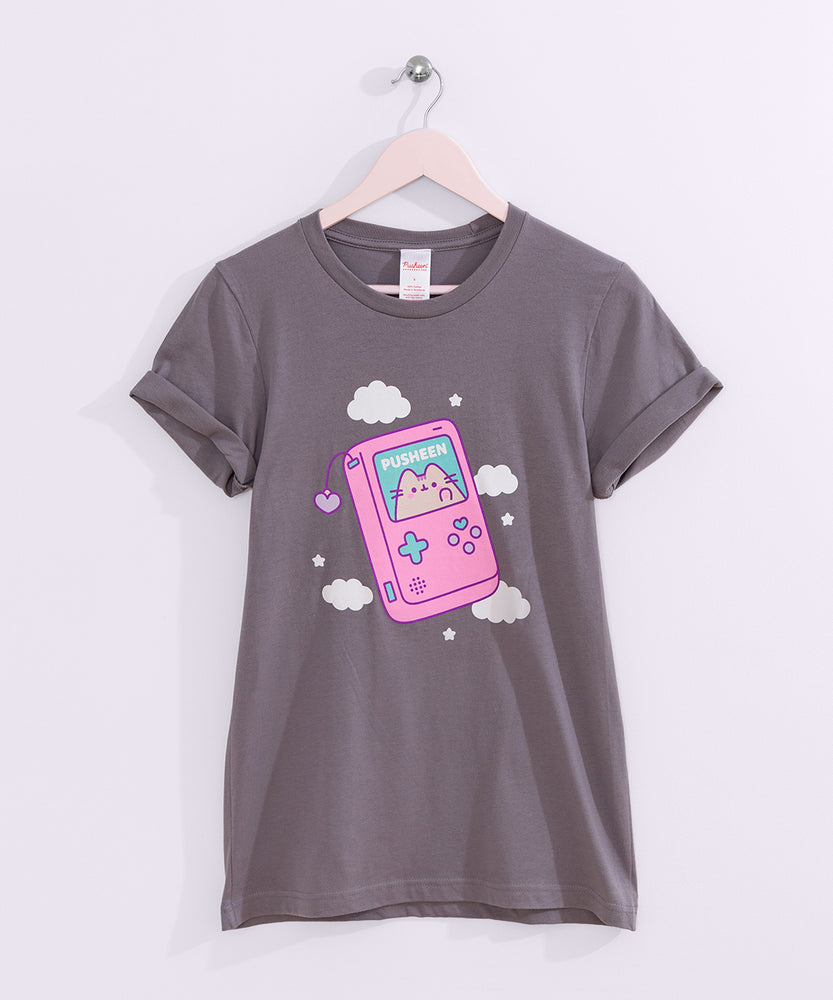 Handheld gaming console printed on a grey tee with the short sleeves rolled up that hangs on a light pink hanger. 