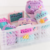 Front view of Gamer Pusheen Surprise Plush assortment. Pusheen the Cat has taken the form of seven miniature gaming accessories in plush keychain form. The gaming blind box plush have a pastel color palette including pinks, purples, blues, and yellows. 
