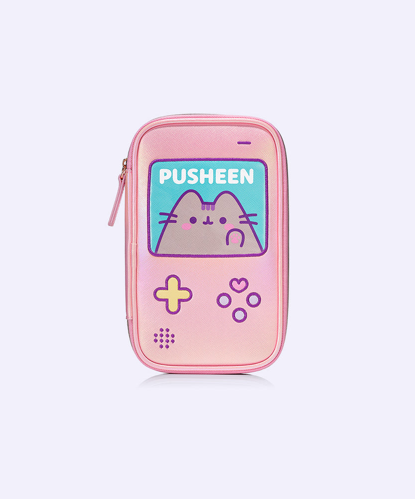 Front view of the pink brush bag that features Pusheen the Cat. The rectangular shape imitates a classic handheld gaming console. The case has a large square featuring Pusheen blushing and various gaming buttons.  