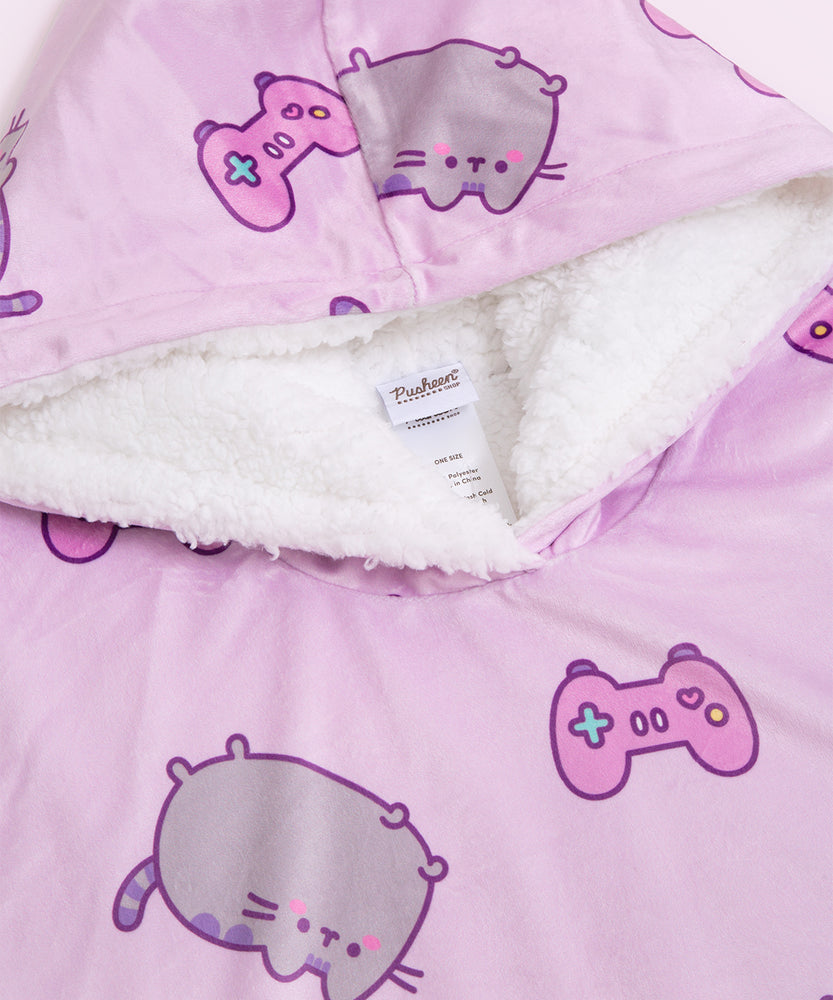 A close-up view of the hoodie hood interior. The white sherpa fabric accented the white details in the all-over-print of the  a blushing gray and purple cat with a purple gaming controller.