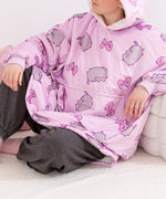 Model wearing a purple hooded blanket with cartoon cat designs and gaming accessories.