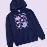 Full view of Gaming Pusheen Hoodie. The large, printed graphic in the center of the front of the sweatshirt features a white grid with Pusheen and her gaming essentials in front. Above the graphic is the phrase “cozy gamer.” 