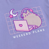 A close-up view of the screen printed graphic on the Gaming Pusheen Tee. In the graphic, the grey tabby cat is outlined in light purple and is shown wearing headphones and is sitting in front of a laptop.  