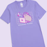 Front view of the Gaming Pusheen Tee. The light purple tee-shirt features a moon and star graphic in the top left corner of the front printed graphic. Under the graphic that spans the wearer’s chest is the phrase “Weekend Plans.” 