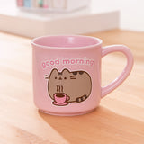 Pink Pusheen mug with a gray tabby cat next a steaming hot beverage with the phrase 'good morning' above the cat graphic.