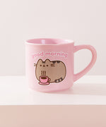 Back view of Pusheen pink mug. The light-pink cup features a grey and brown graphic of Pusheen relaxing with her own hot beverage in a pink mug. The graphic on the back matches the graphic on the front. 
