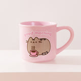 Back view of Pusheen pink mug. The light-pink cup features a grey and brown graphic of Pusheen relaxing with her own hot beverage in a pink mug. The graphic on the back matches the graphic on the front. 
