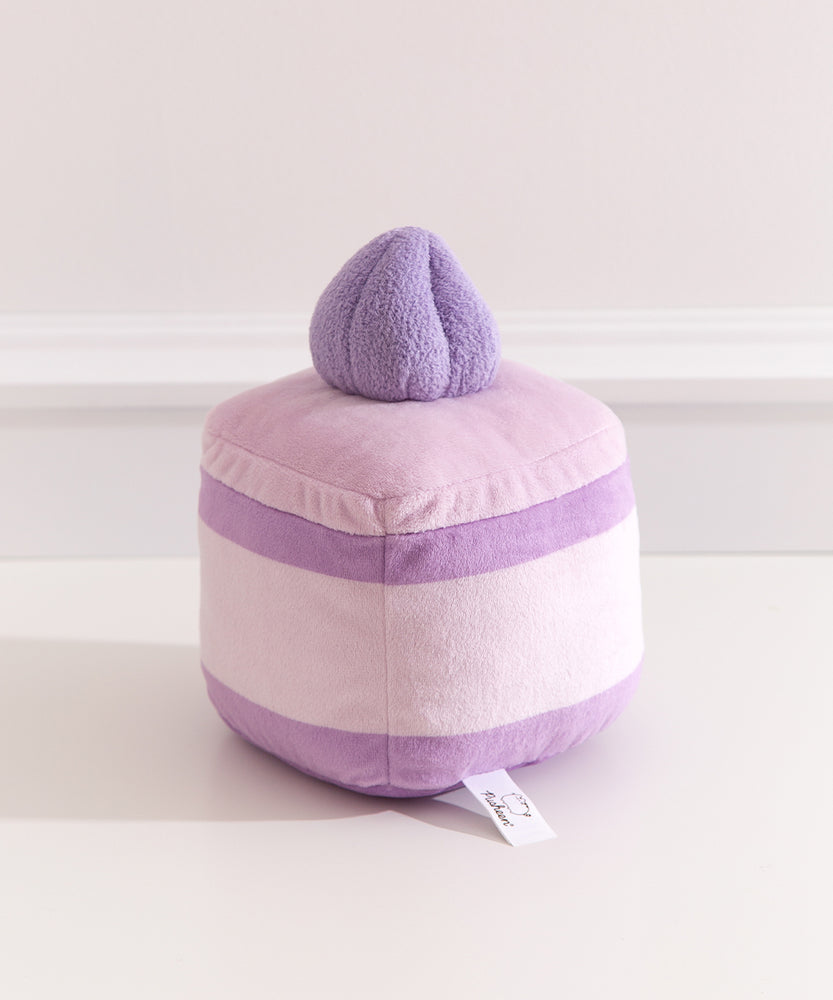 Back view of the Lavender Sponge Cake plush. The cake plush has light purple icing, medium purple cake layers, and light purple cream extending around the back of the plush.