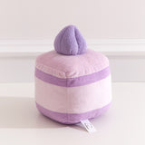 Back view of the Lavender Sponge Cake plush. The cake plush has light purple icing, medium purple cake layers, and light purple cream extending around the back of the plush.