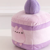 Close-up of the Pusheen plush on the Cake Squisheen. Pusheen's eyes, nose, and whiskers are embroidered in black while her three head stripes are a medium purple embroidery color.