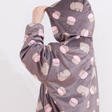 Model stands to the side while wearing the Pusheen Wearable Blanket Hoodie with the grey hood over their head. The print all over continues from the body onto the hood. The oversized hoodie fits most.  