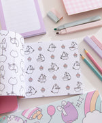 Mini Pusheen Coloring & Activity Book is opened to two white coloring pages with black graphics. On the left page is a repeating pattern of Stormy & Pip being carried by balloons. On the righthand page is a repeating pattern of Pusheen the Cat baking with cupcakes.