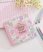 Front cover of pink and pastel Pusheen coloring book by Claire Belton.