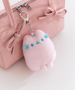 Small pink Dreamsheen plush bag charm with paw print details on the bottom. 