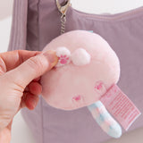 Model holding one of the front paws on the bag charm to show the embroidered paw print detail.