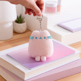 Light pink plush keychain with model holding the attached lobster claw clip.