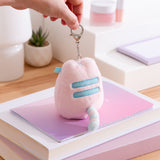 Model holds lobster claw clip keychain on the Pink Dreamsheen Bag Charm. The fluffy pink bag charm has light blue embroidery details. 