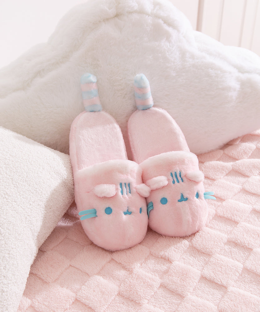 Pair of pink Pusheen slippers with light blue embroidery details of Pusheen the Cat's face and whiskers.