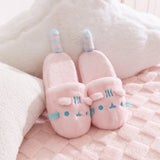 Pair of pink Pusheen slippers with light blue embroidery details of Pusheen the Cat's face and whiskers.