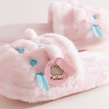 Close-up of the pink Pusheen Label logo tag attached to the 3D ear on the plush slippers.