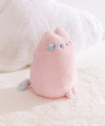 Side quarter view of the Pink Dreamsheen Plush. The striped tail can be seen extending off the back of the plush in this image.