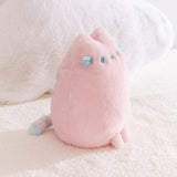 Side quarter view of the Pink Dreamsheen Plush. The striped tail can be seen extending off the back of the plush in this image.