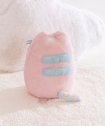Back view of the plush toy with light blue detailing on back and tail. 