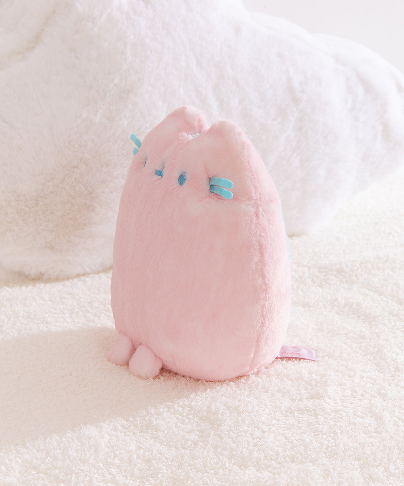 Quarter side view of the Pink Dreamsheen Plush. The 9" tall plush has two front paws that extend off the bottom front of the plush. 