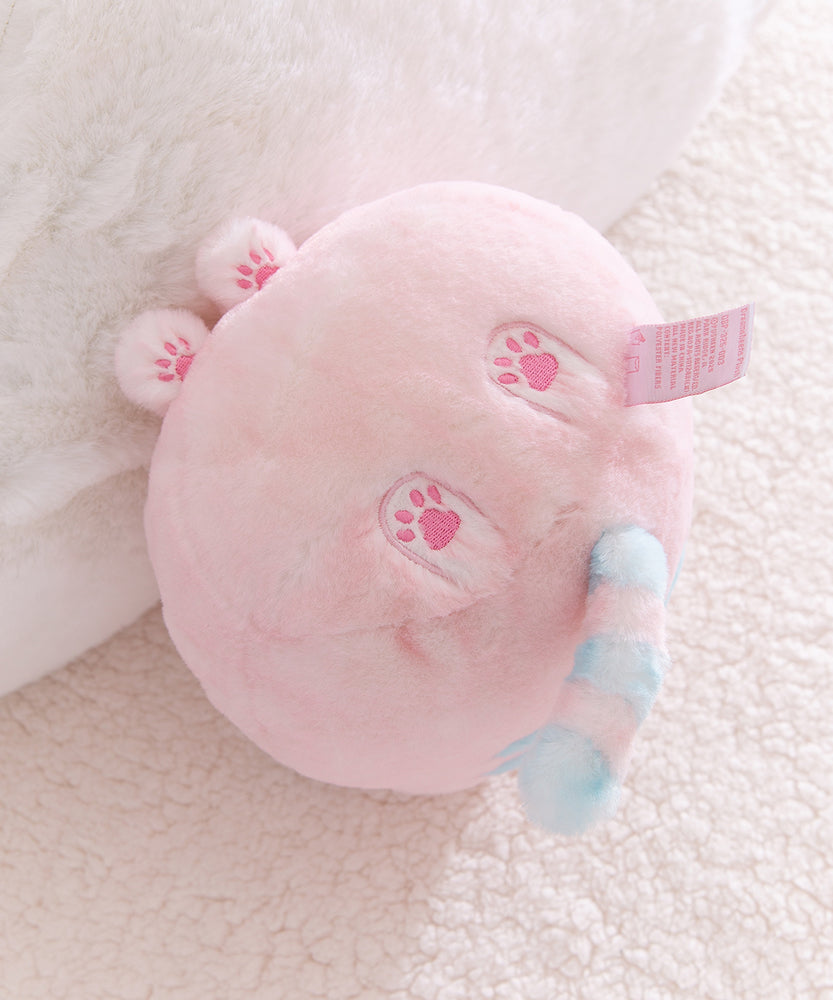 Pink plush toy with paw prints on a soft surface.
