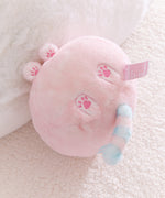 Pink plush toy with paw prints on a soft surface.