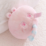 Pink plush toy with paw prints on a soft surface.