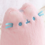 Close-up of a pink plush toy with blue accents on a light background.