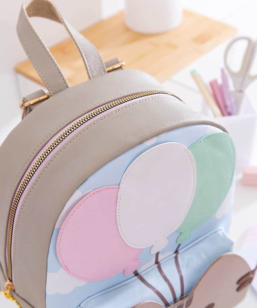 Close-up view of the closed top zipper and cloud motif on the cat-themed backpack. 
