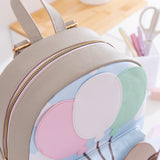 Close-up view of the closed top zipper and cloud motif on the cat-themed backpack. 