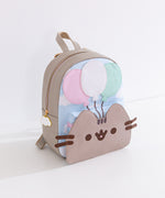 Pusheen 15th Anniversary Backpack sits on a white desktop. The grey backpack has Pusheen's 3D face on the front with a blue sky and clouds pattern above. 