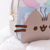 Close-up of Pusheen's smiling face on the Balloons backpack. Pusheen's brown whiskers are 3D and stick out to the sides of the backpack. 