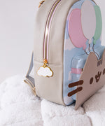 Close-up side view of the backpack. The gold and pink zipper has a white cloud zipper charm pull outlined in gold. 