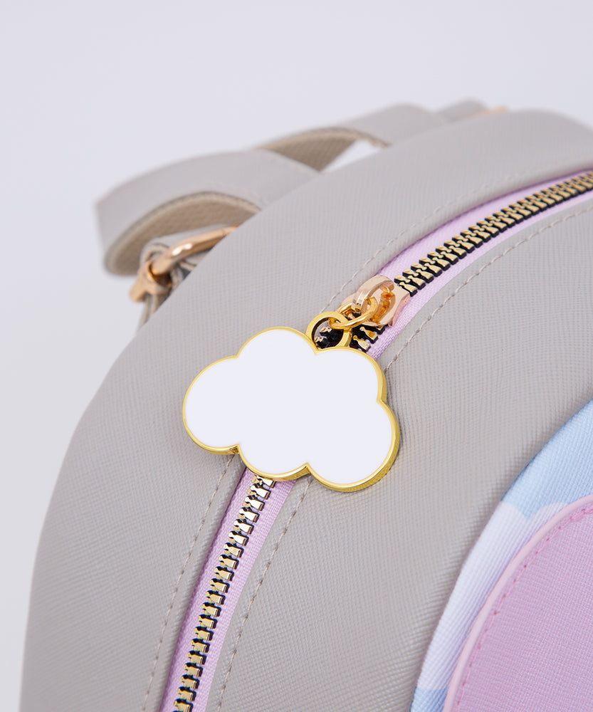 Close-up of the gold and white cloud zipper pull on the grey cat backpack. 