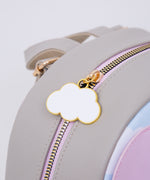 Close-up of the gold and white cloud zipper pull on the grey cat backpack. 