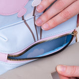 Model holds open front pocket zipper to show interior sky and clouds pattern. 