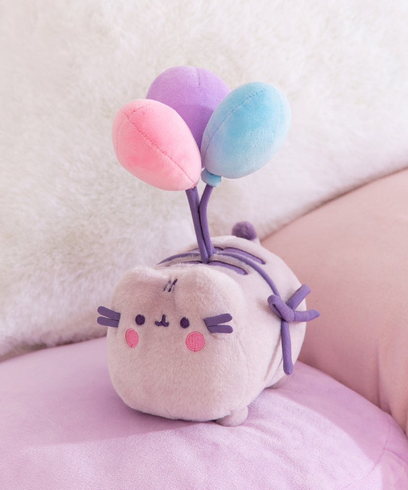 Plush toy with pastel-colored balloons on a soft surface