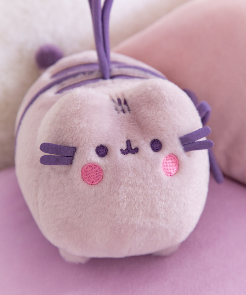 Plush toy with a embroidered face design on a pink background
