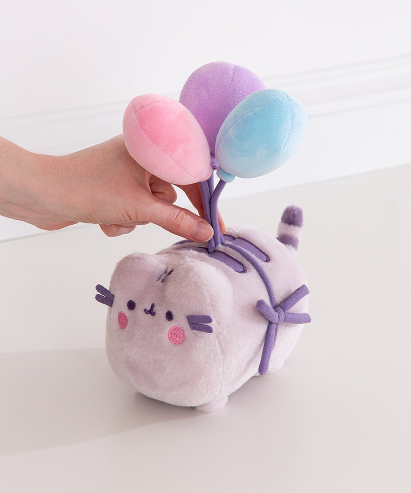 Model holds balloon strings on 15th Anniversary Plush to showcase the size and scale of the plush toy.